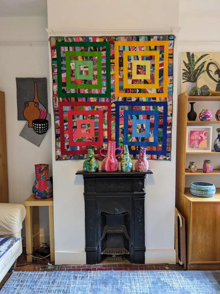 Kate Sandford living room with bright squares quilt and fiber vessetls