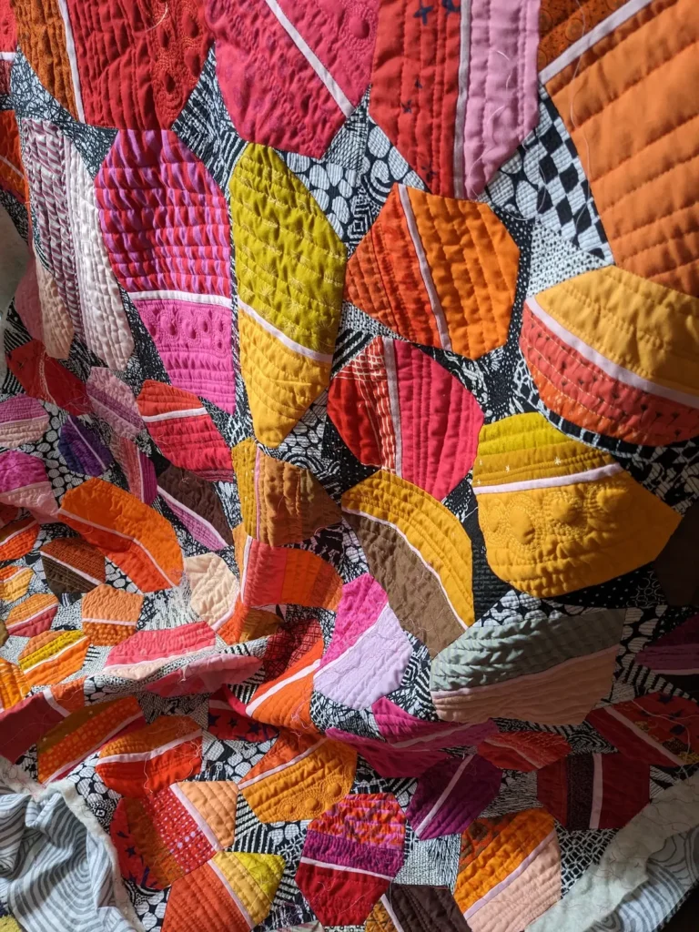 Close up of an orange and yellow quilt by Kate Sandford