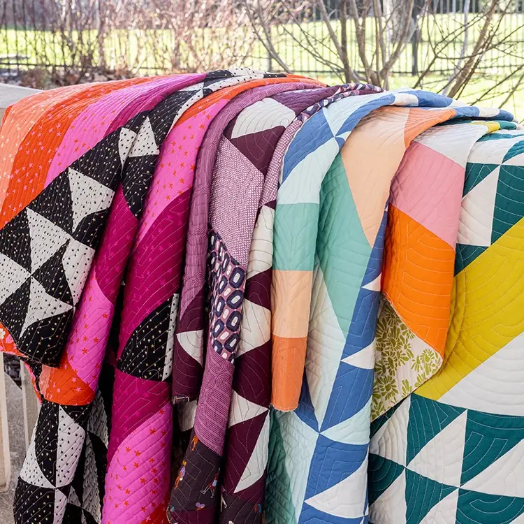 Several quilts over a banister by Lilo Whitener-Fey