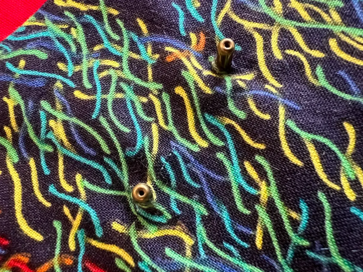 Showing the rivets placed through the holes in the bag ready for the hanlges