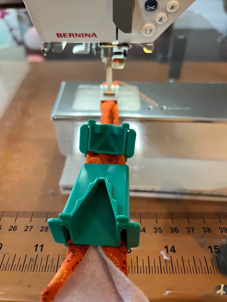 Fabric tube with tool showing how the two pieces make the double fold in one step