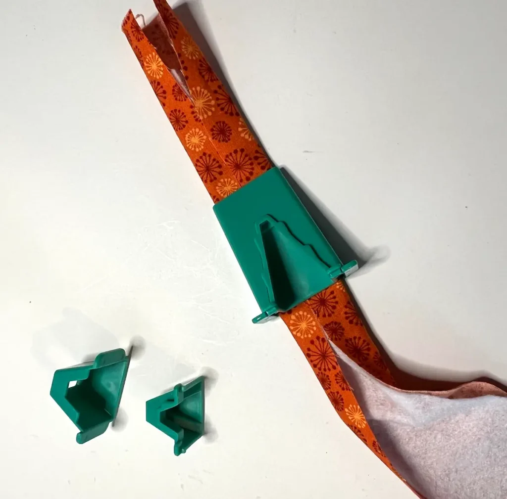 Fabric tube with tool showing the first fold to the middle