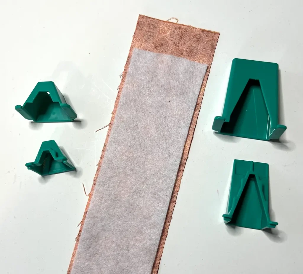 Fabric tube with tool showing the tool and fabric and batting