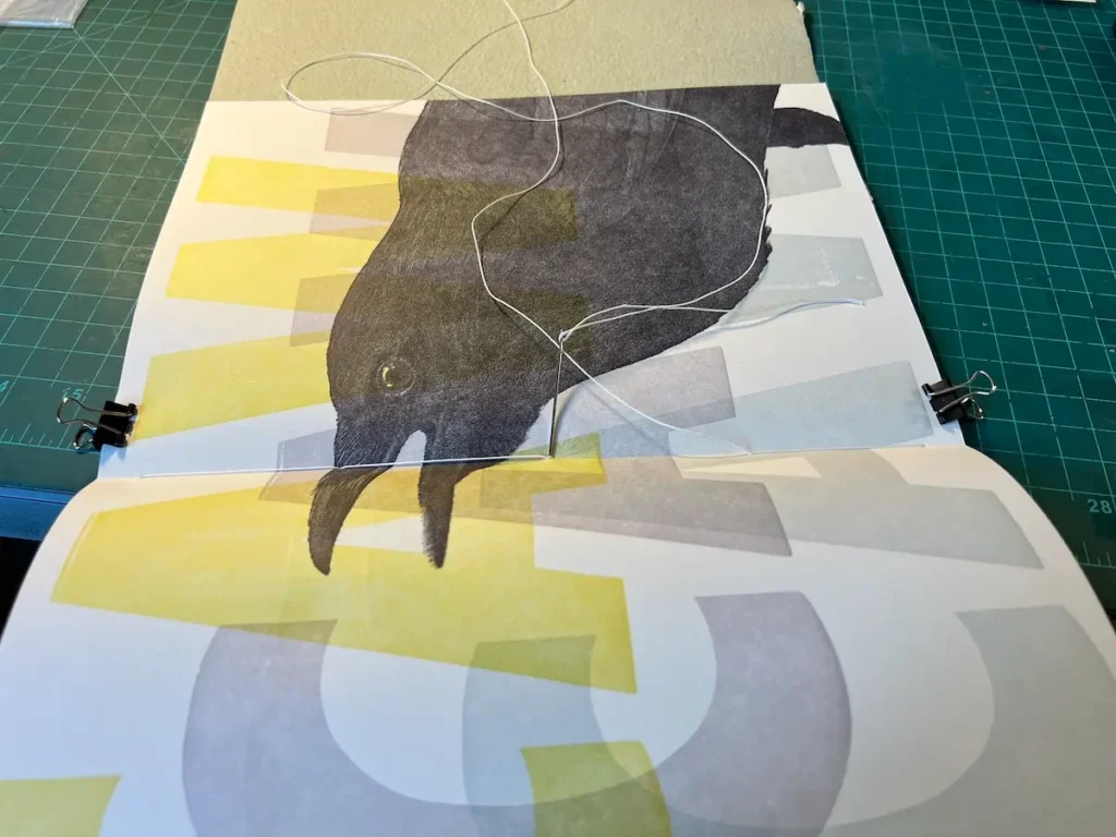 Listen sewing the bindings on the books by Rebecca Chamlee