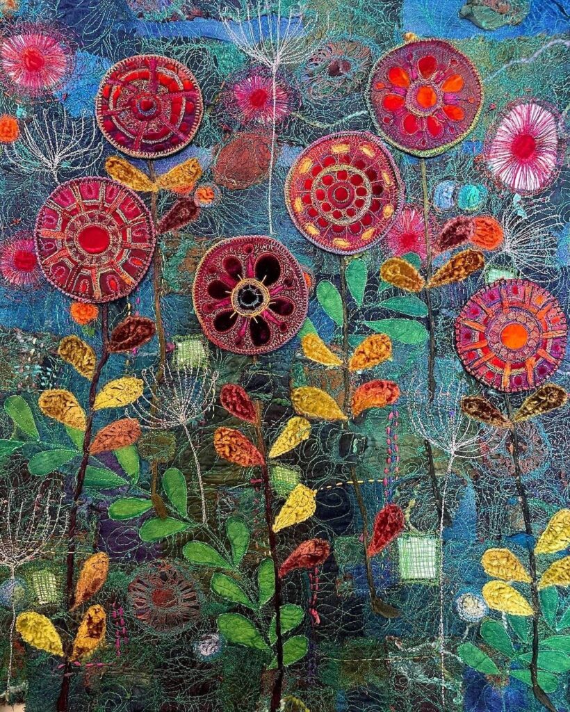 Red flowers and greenery on a blue background art quilt by Michelle Mischkulnig