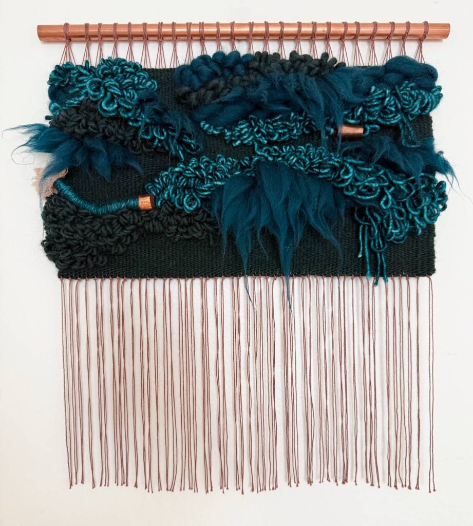 Teal weaving on a copper pipe by Adriene Busch