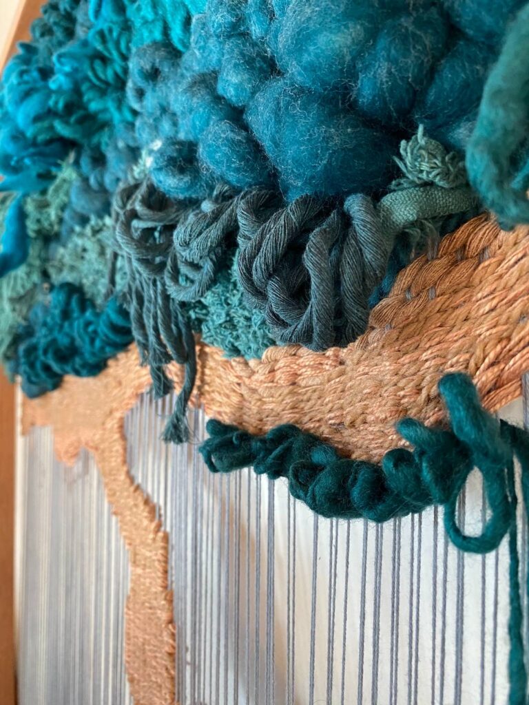 Work in progress on a teal weaving by Adriene Busch
