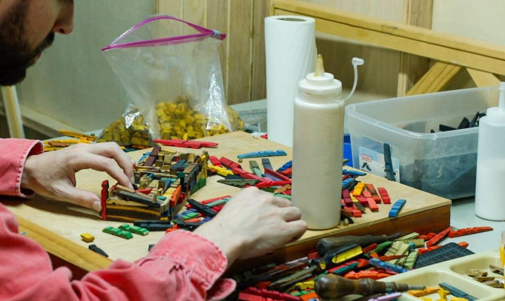 Davis Choun working on one of his clothes pins pieces
