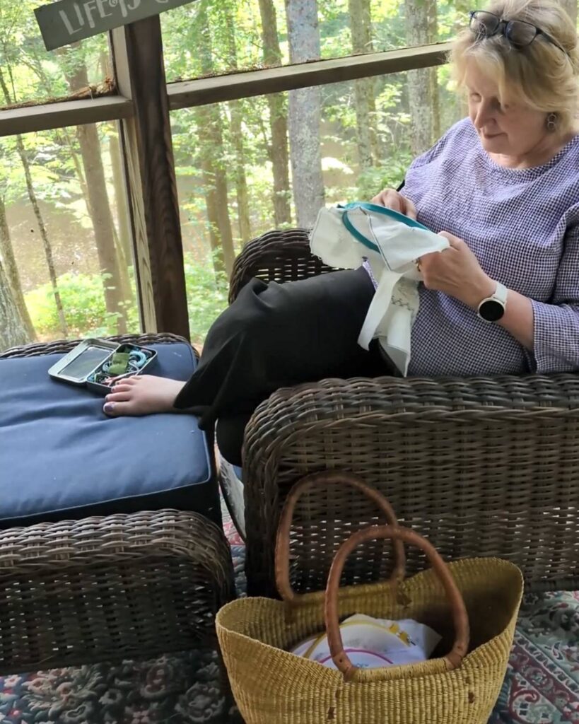 Debbie Hodge sitting and stitching