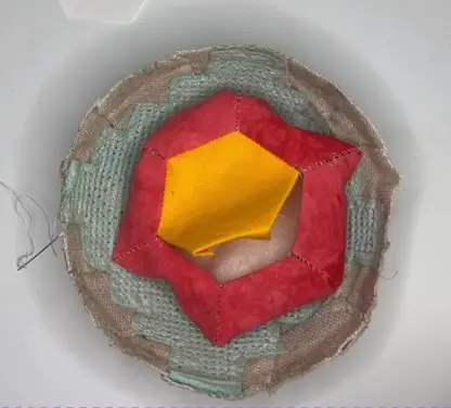 Hexie flower pincushion place in a bowl to catch any loose walnuts