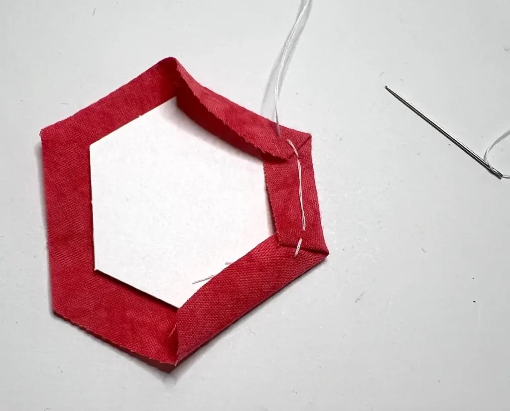 Thread basting second fold secured with a stitch