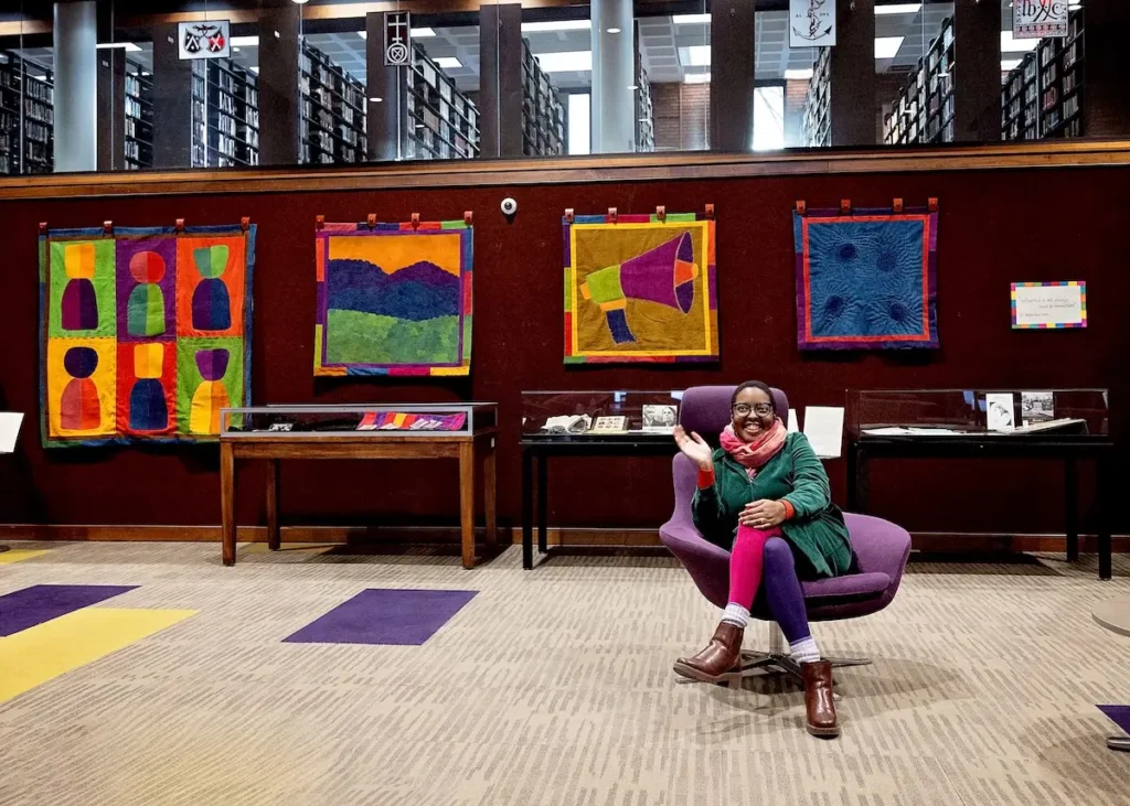 Dr. Jaleesa Wells in the library wiht her work