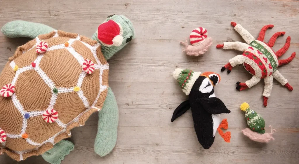 Knitted turtle, penquin, crab and a few snails in holiday attire by Karla Courtney