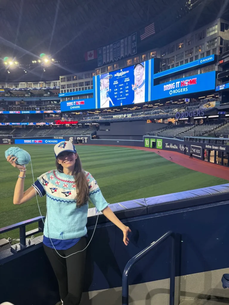 Karla Courtney at a blue jay game with her partially knit sweater