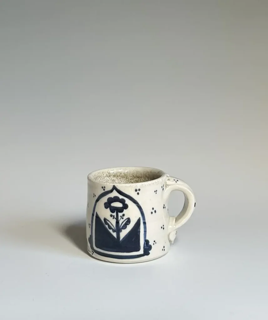 Pottery mug made by Summer Brendlinger with a single happy flower