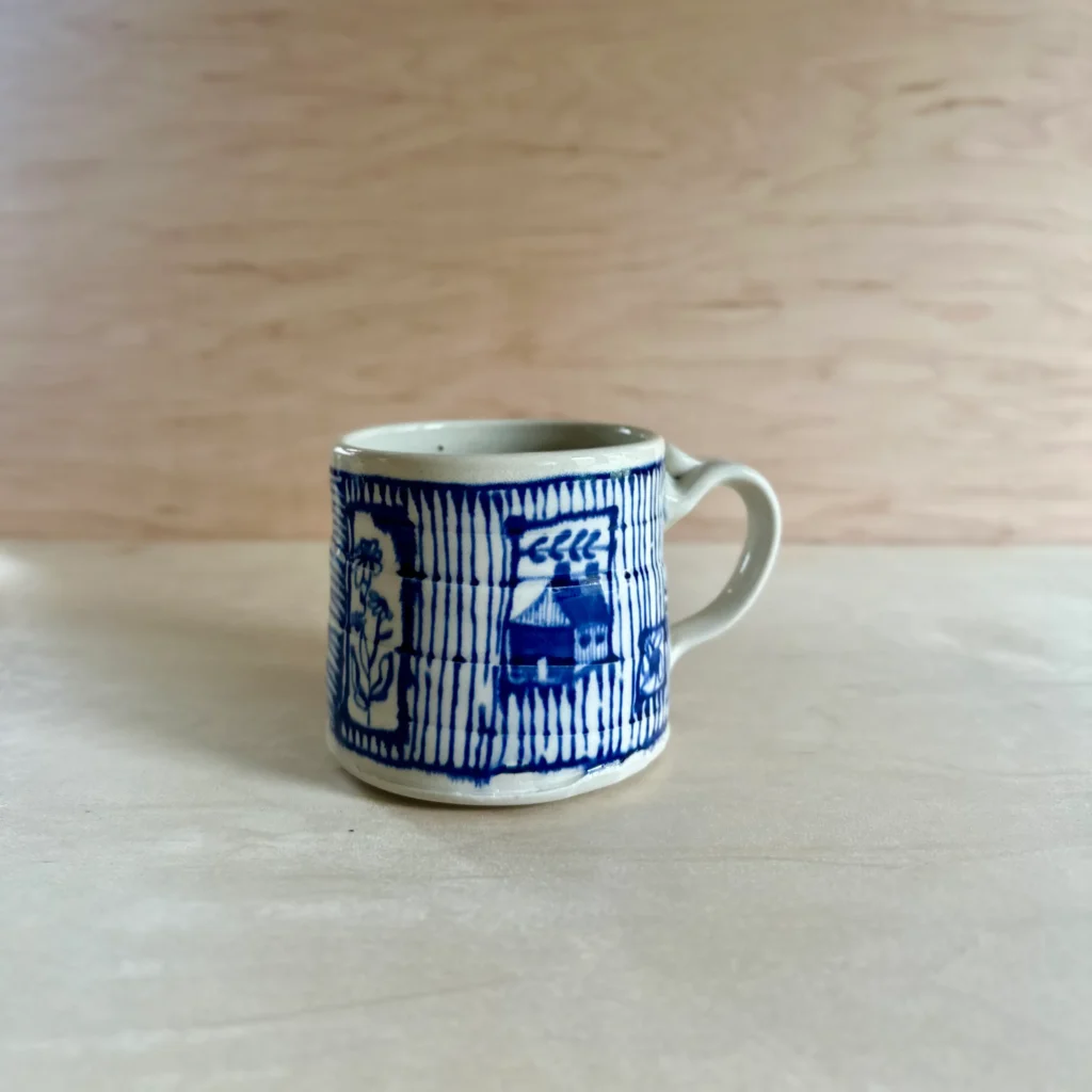Quilterly mug with a house and flowers made by Summer Brendlinger