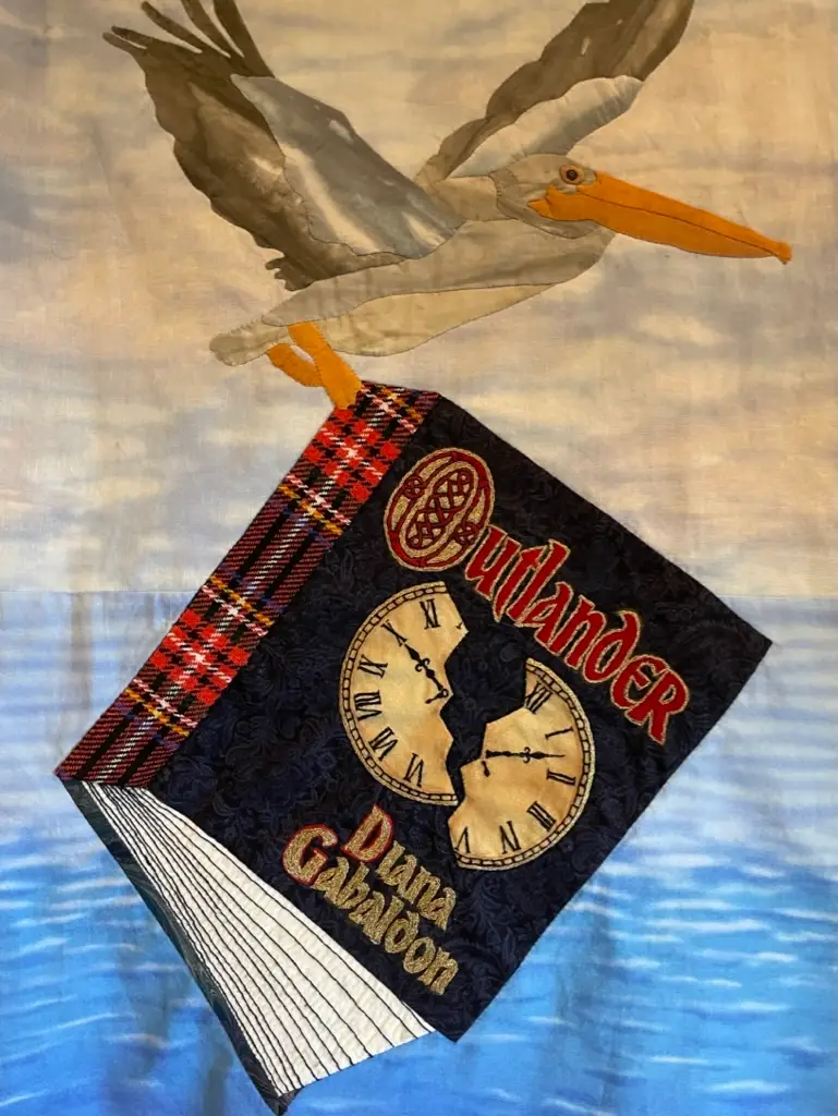 Outlander book title quilt on the patchwork dress made by Teri Biglands