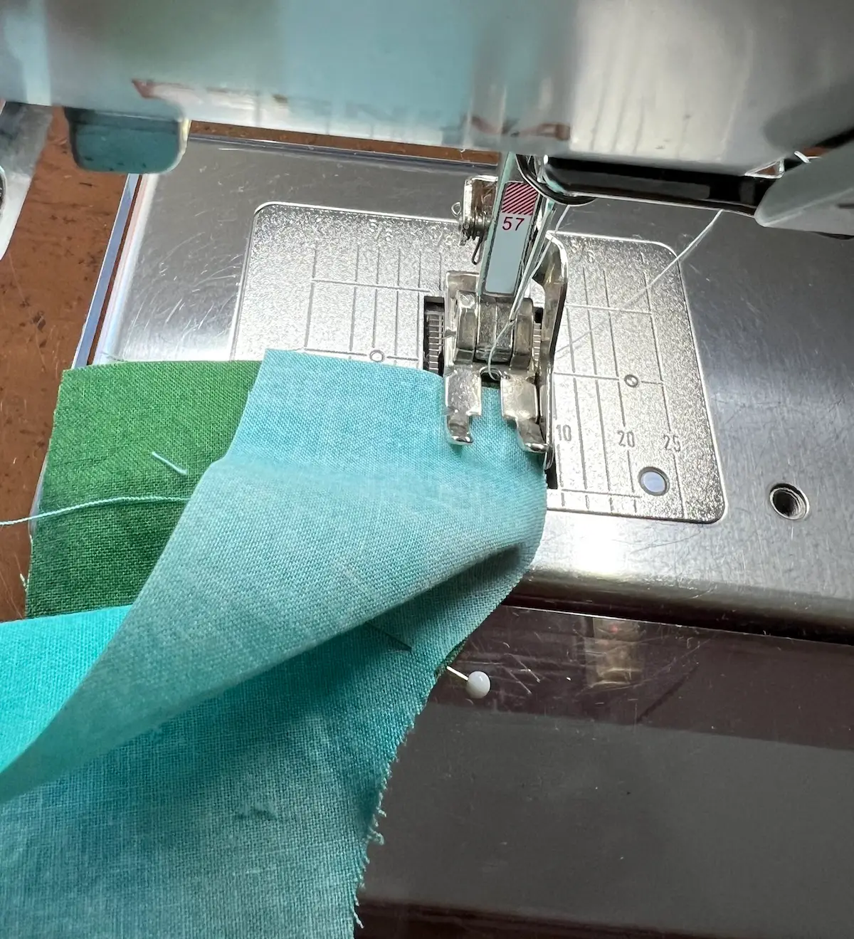 Sewing the pie and the L for the drunkard path block together to make the corners of the button quilt block