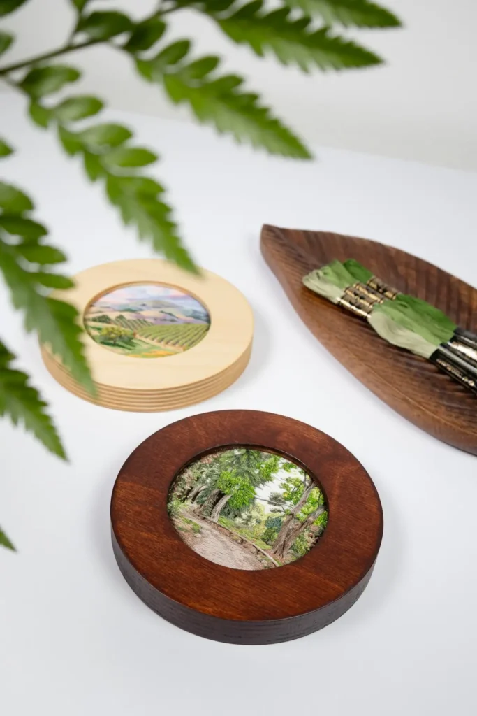 Two small embriodery art works in circle frames by Cassandra Dias