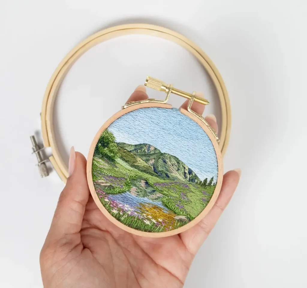 Landscape embroidery art with river and hills by Cassandra Dias