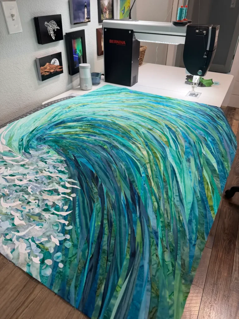 Showing a piece in progress of being quilted by Cynthia Minoli