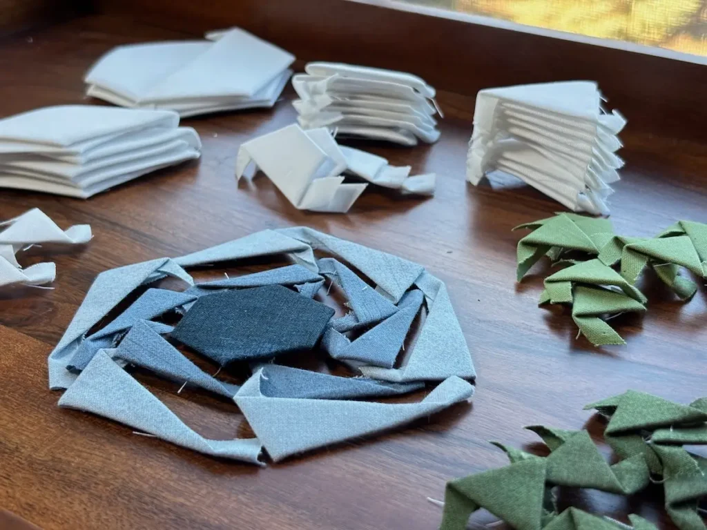 Piles of small pieces ready to sew for the Hexies in Bloom quilt by Marie-Elise McNeeley