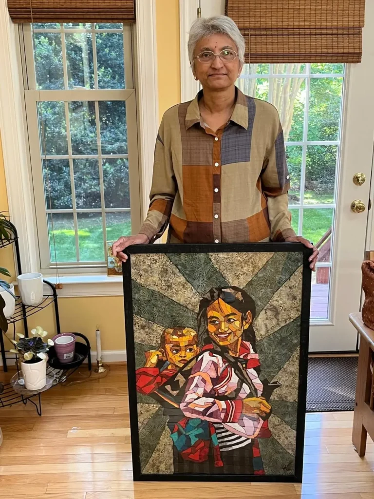 Mihira Karra holding her painting of a woman wiht a baby in a backpack