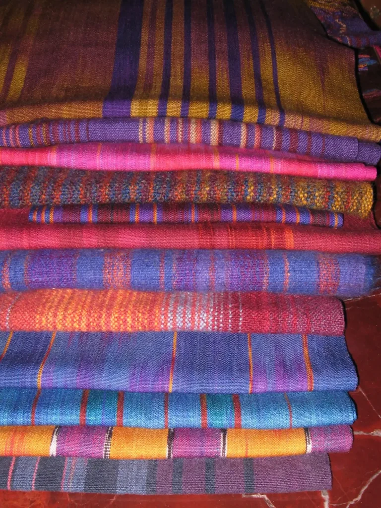 Stack of handspun shawls and scarved made by Sara Lamb