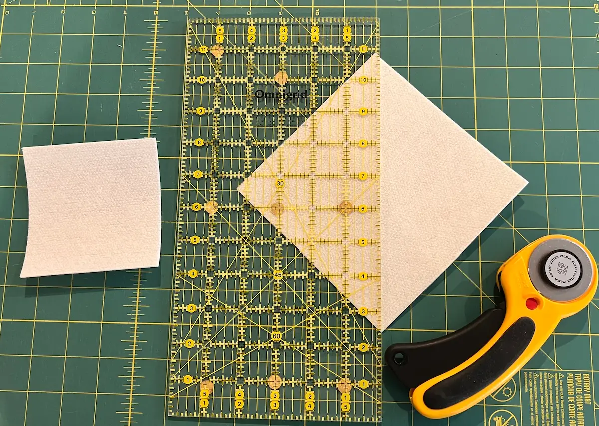 For the top of the fabric box, cut the larger piece in half diagonally