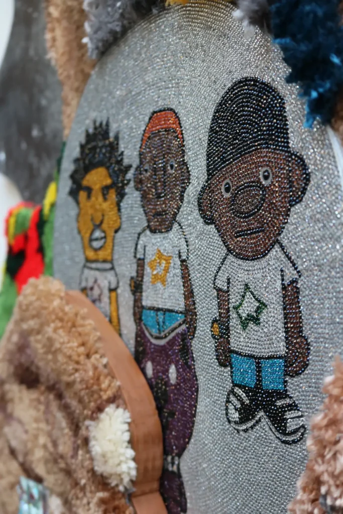 Detail of beading of three boys by Kid Kardiac