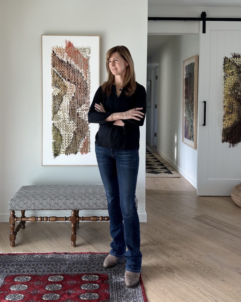 Libby Raab artist photo with weaving behind her