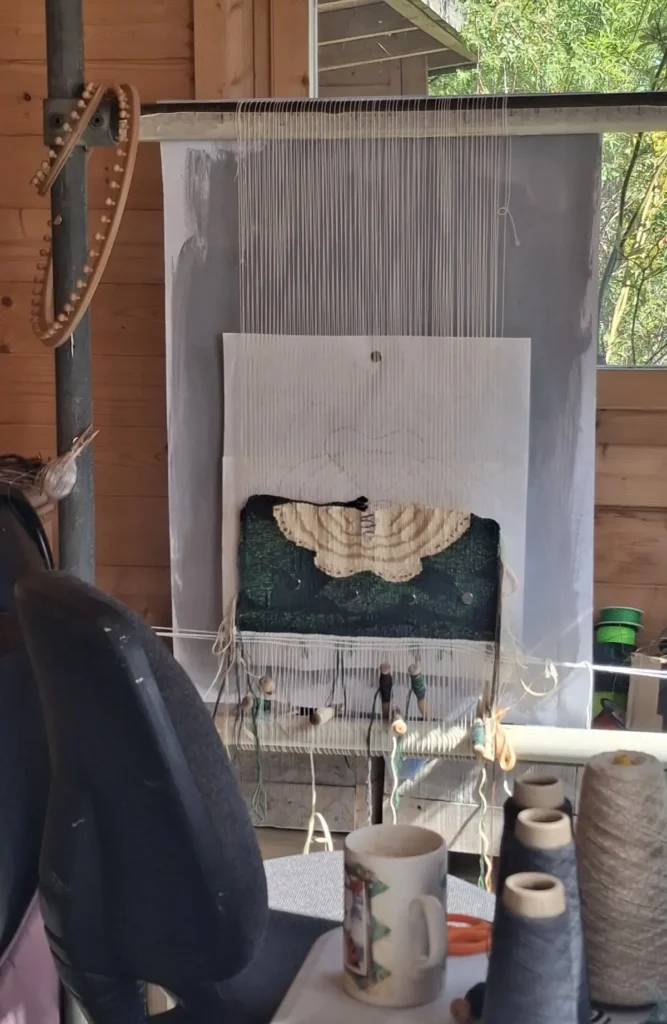 Tapestry loom with moth tapestry being woven by Lucy Sugden