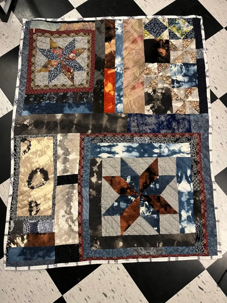 Quilt with stars in diagonal corners by Scot Augustston
