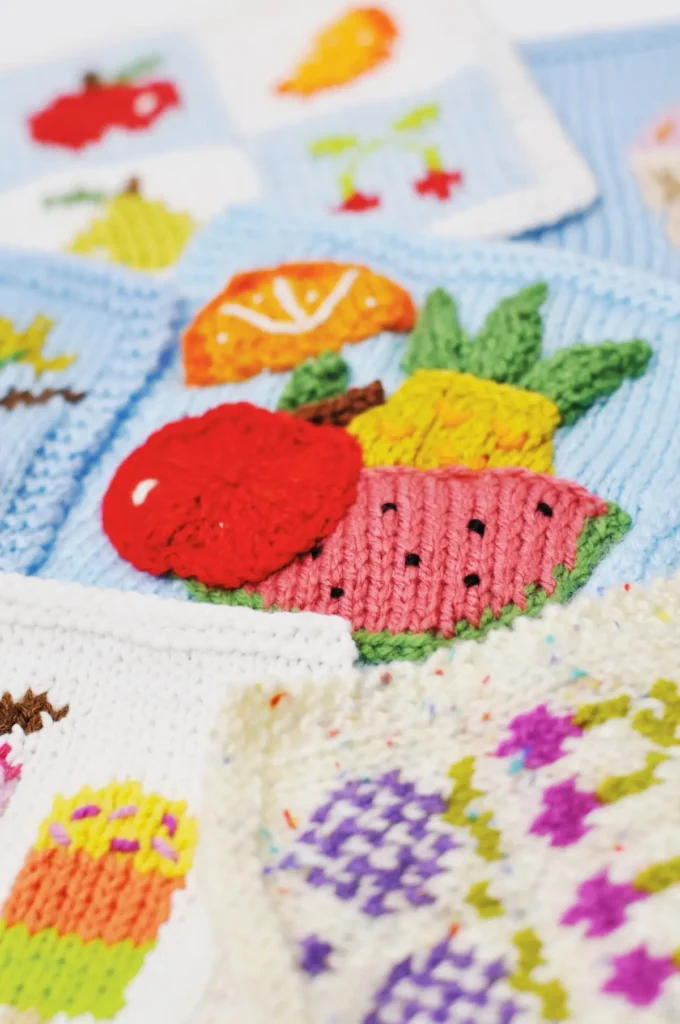 Variety of samplers knitted by Sian Brown including apples, watermelon, orange, pineapple and more!
